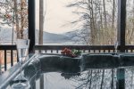 Image snow covered mountain views from a lakefront hot tub